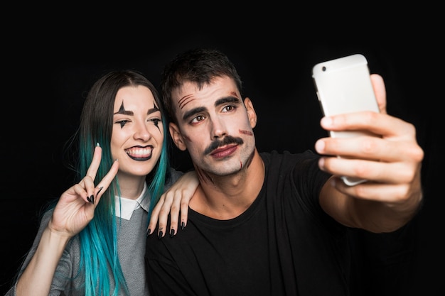 Niña sonriente con hombre tomando selfie en teléfono