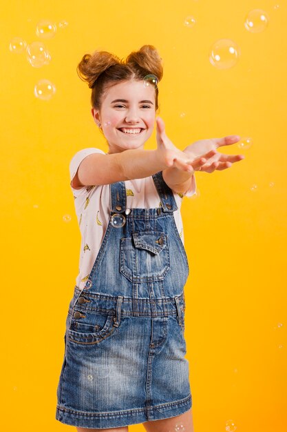 Niña sonriente jugando con burbujas