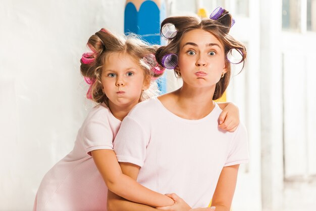 Niña sonriente jugando con su madre en blanco