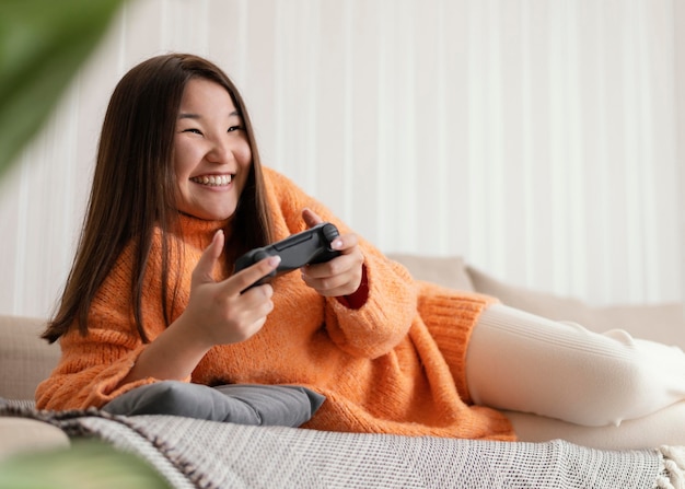 Niña sonriente jugando videojuegos con controlador