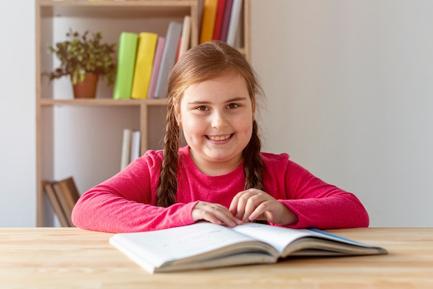 Niña sonriente leyendo