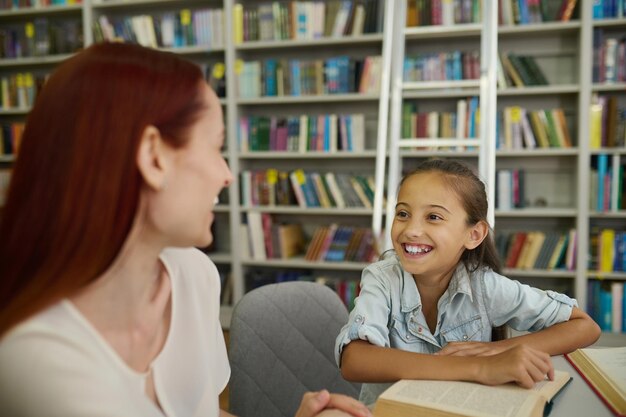 niña sonriente, el mirar, mujer se sentar, en la mesa