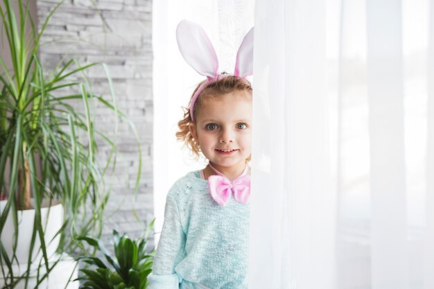 Niña sonriente con orejas de conejo