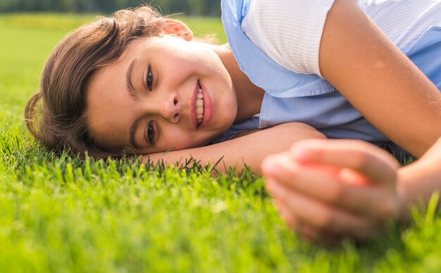 Niña sonriente, permanecer en hierba