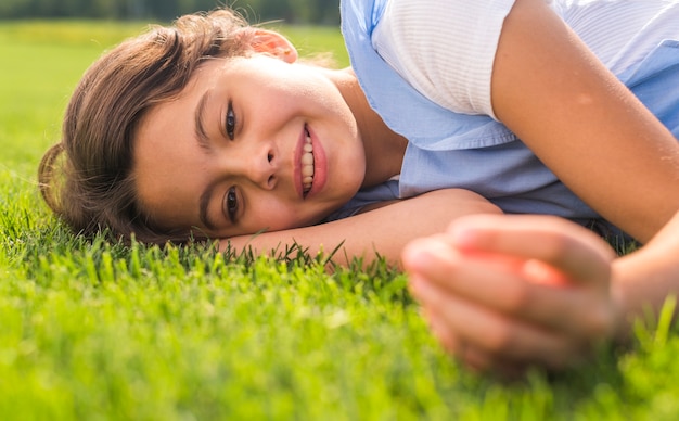 Niña sonriente, permanecer en hierba