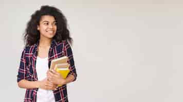 Foto gratuita niña sonriente con pila de libros