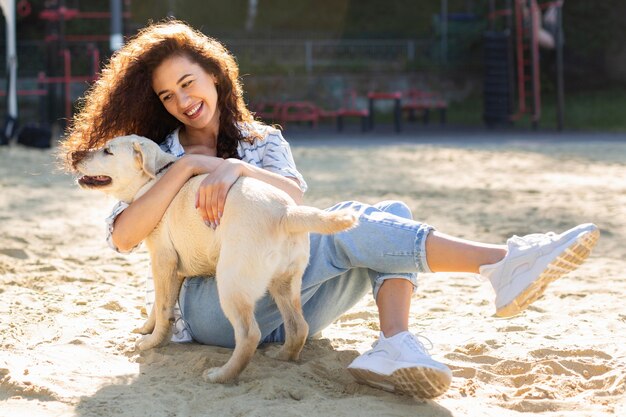 Niña sonriente posando afuera con su perro