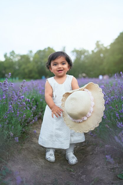 Niña sonriente posando en la pradera de lavanda