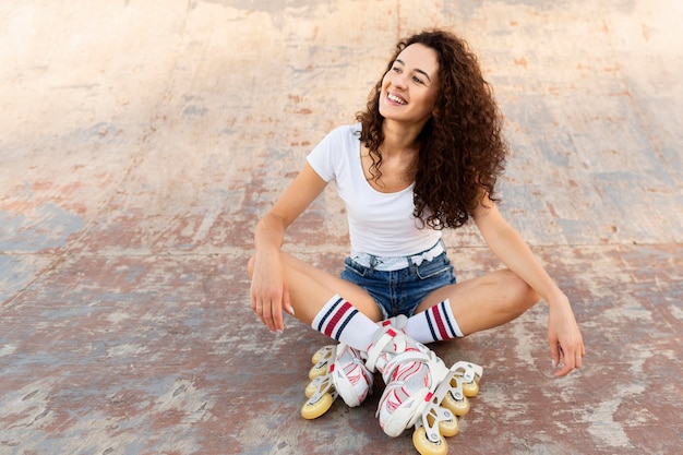 Niña sonriente posando en sus patines con espacio de copia