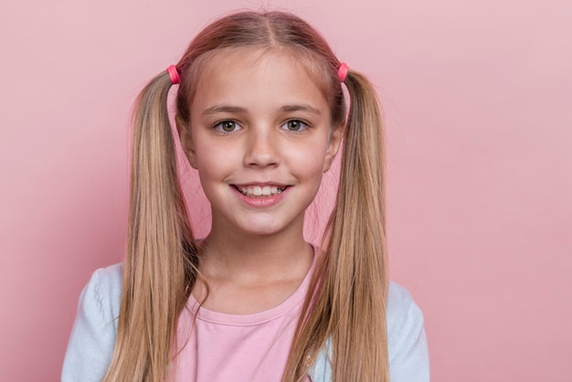 Foto gratuita niña sonriente con primer plano de colas de caballo