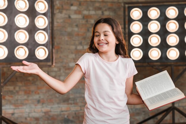 Niña sonriente realizar contra la luz de la etapa