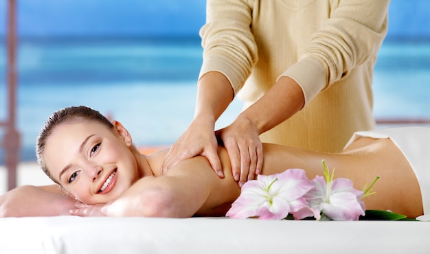 Foto gratuita niña sonriente recibiendo masaje spa en salón de belleza - espacio natural. adentro
