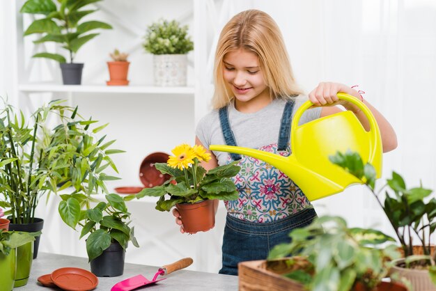 Niña sonriente regando las flores