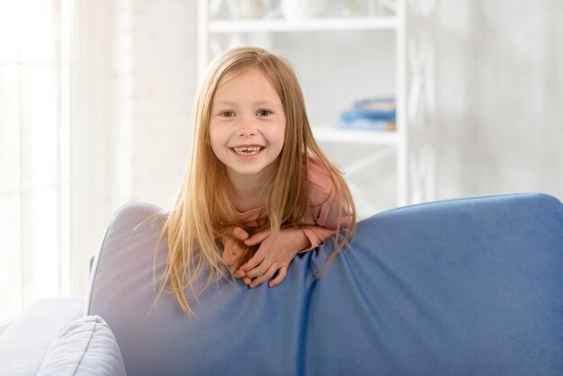 Niña sonriente en el sofá