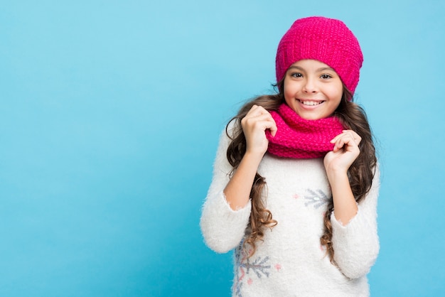 Niña sonriente con sombrero y bufanda