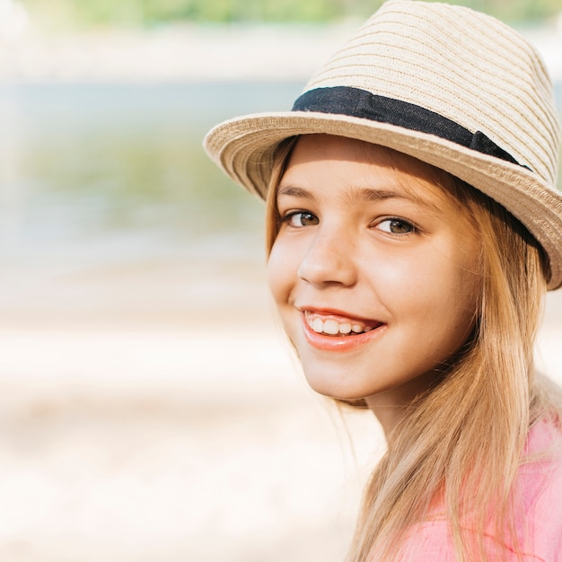 Foto gratuita niña sonriente, en, sombrero, en, orilla