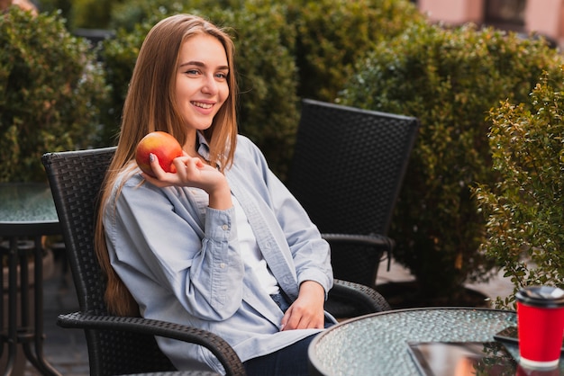 Niña sonriente sosteniendo una manzana