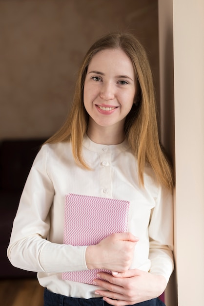 Niña sonriente sujetando un cuaderno