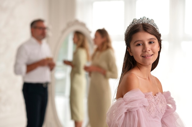 Niña sonriente de tiro medio con corona plateada