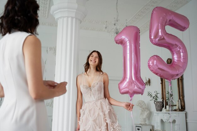 Niña sonriente de tiro medio con globos