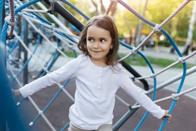 Niña sonriente de tiro medio en el parque