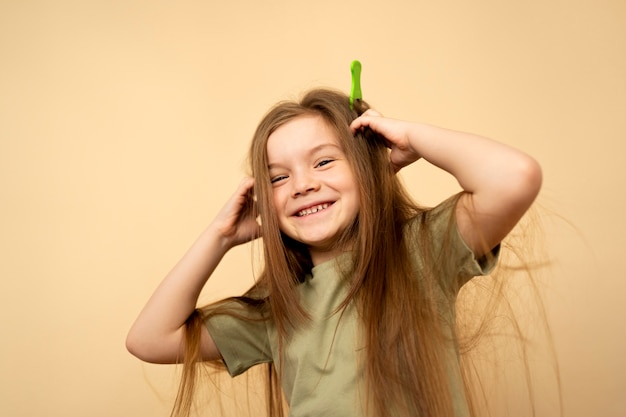 Niña sonriente de tiro medio con peine