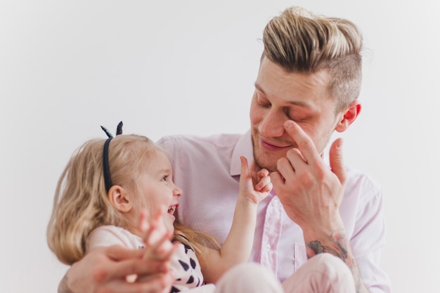 Niña sonriente tocando la cara de su padre