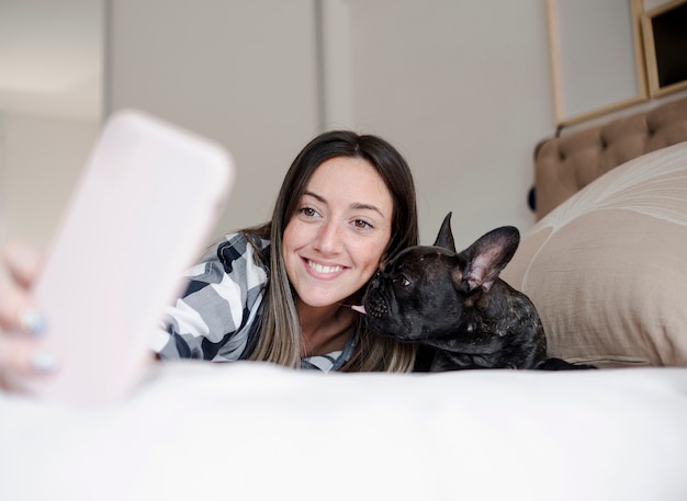 Niña sonriente tomando una selfie con su perro