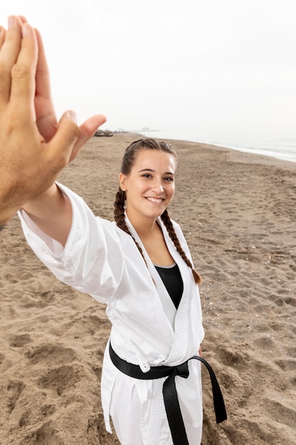 Niña sonriente en traje de artes marciales al aire libre