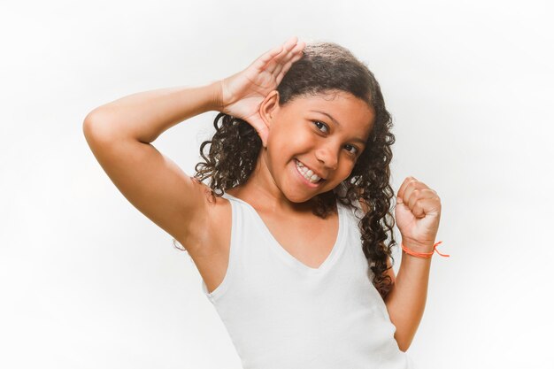 Niña sonriente tratando de escuchar sobre fondo blanco