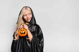 Foto gratuita niña sonriente con el trick or treat bucket