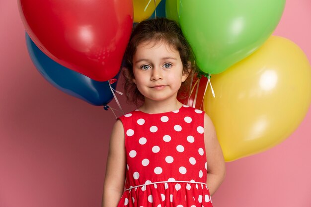 Niña sonriente en un vestido rojo celebrando su cumpleaños