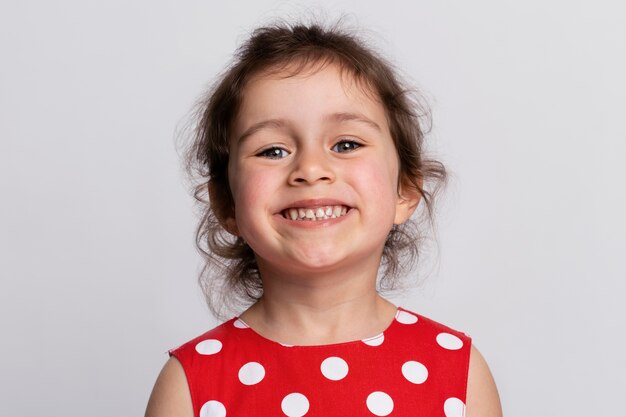 Niña sonriente con un vestido rojo