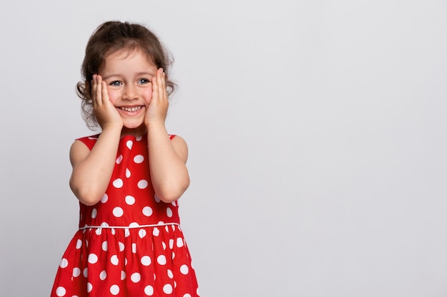 Niña sonriente con un vestido rojo