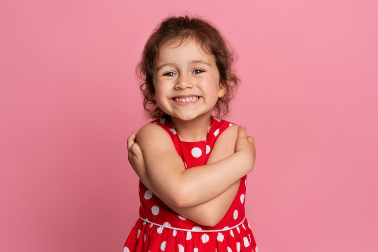 Foto gratuito niña sonriente con un vestido rojo