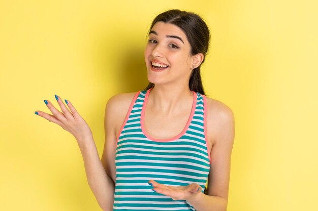 Niña sorprendida abriendo las manos y sonriendo a la cámara Foto de alta calidad