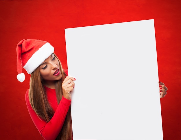 Niña sorprendida mirando un cartel en blanco