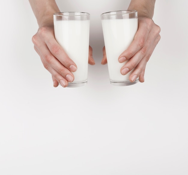 Niña sosteniendo 2 vasos de leche