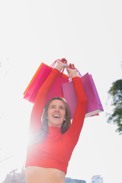 Niña sosteniendo bolsas de compras por encima de su cabeza