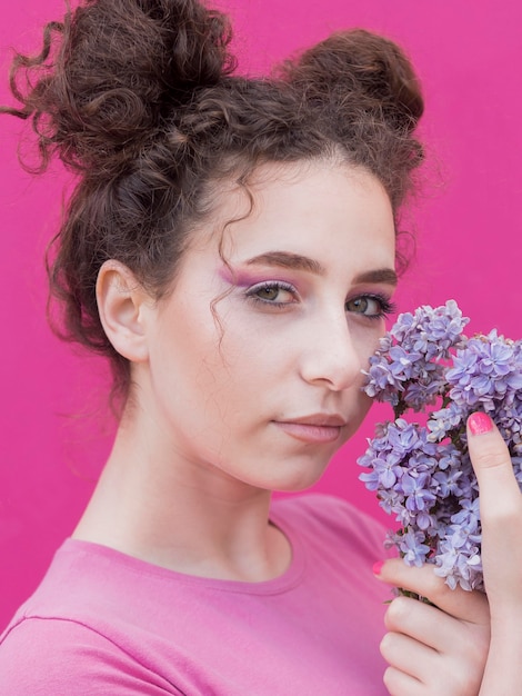 Foto gratuita niña sosteniendo flores lilas