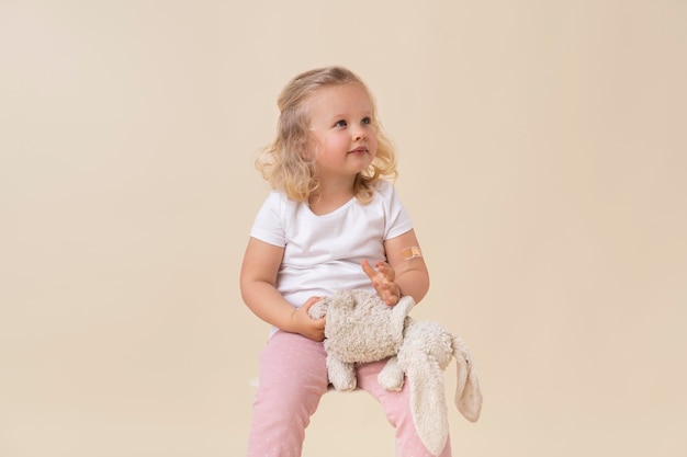 Niña sosteniendo un juguete después de recibir una vacuna