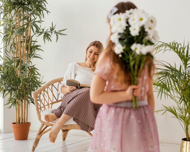 Niña sosteniendo un ramo de flores de primavera como regalo para su madre