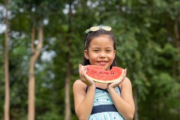 Niña sosteniendo una rodaja de sandía