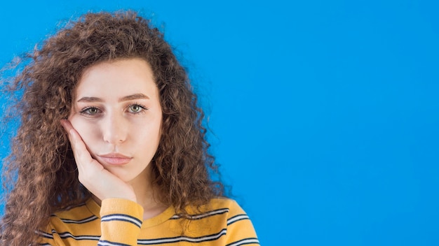 Foto gratuita niña sosteniendo su cara con la mano