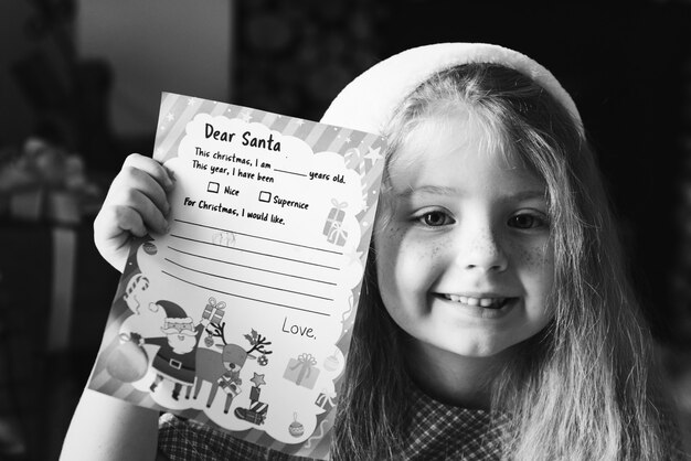 Niña sosteniendo su lista de deseos de Navidad