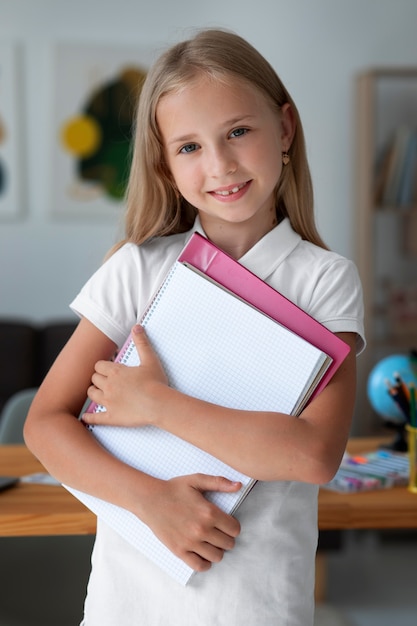 Niña sosteniendo sus libros