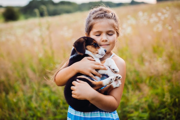 La niña sostiene un perrito en sus brazos