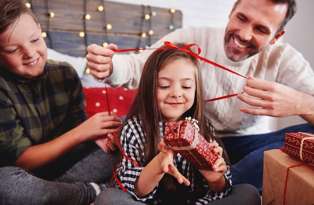 Niña con su familia abriendo regalo de navidad