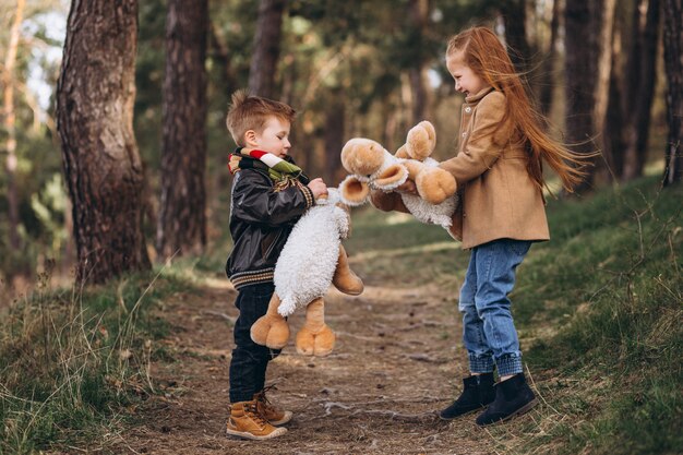 Niña con su hermano pequeño juntos en el bosque