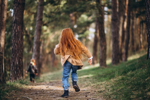 Niña con su hermano pequeño juntos en el bosque